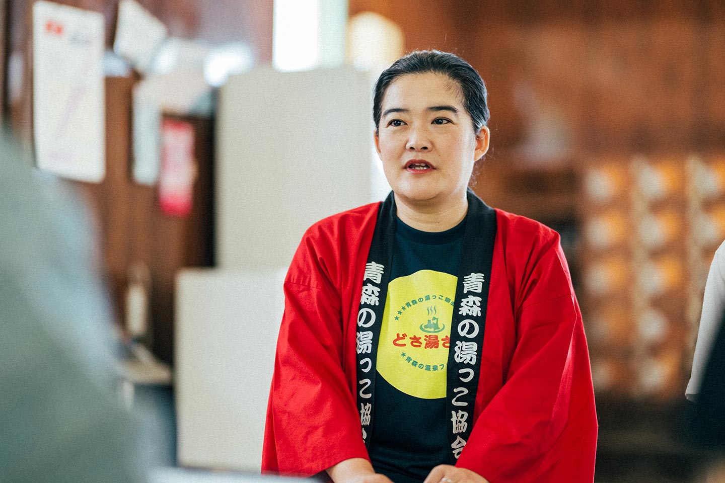 赤いはっぴを着た、青森の湯っこ協会代表の沓掛麻里子さん