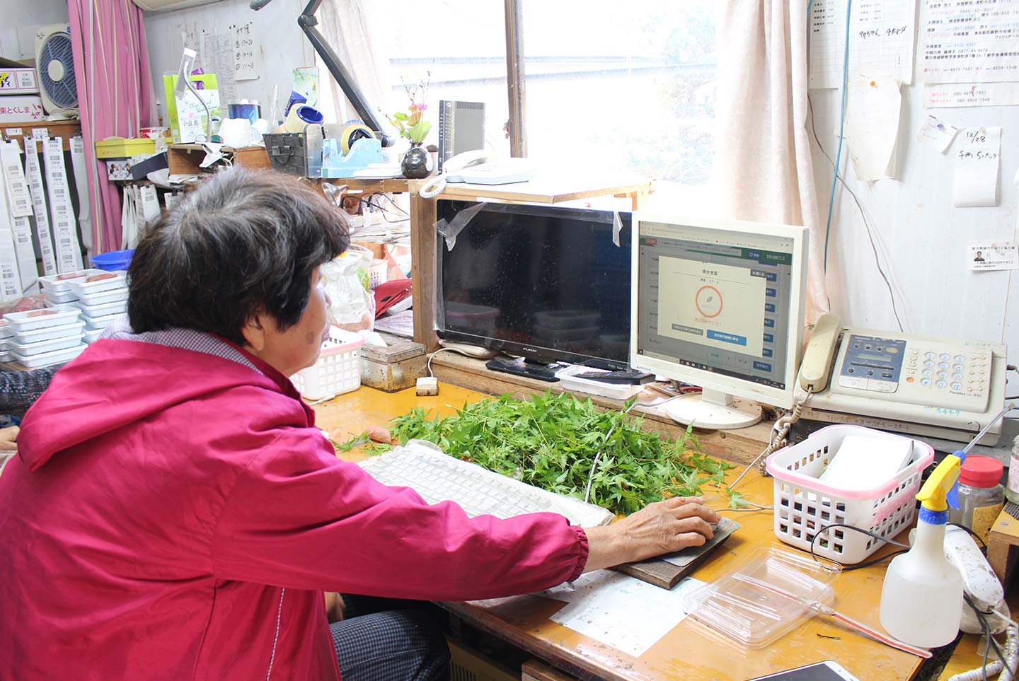 作業場でパソコンを操作する農家さん