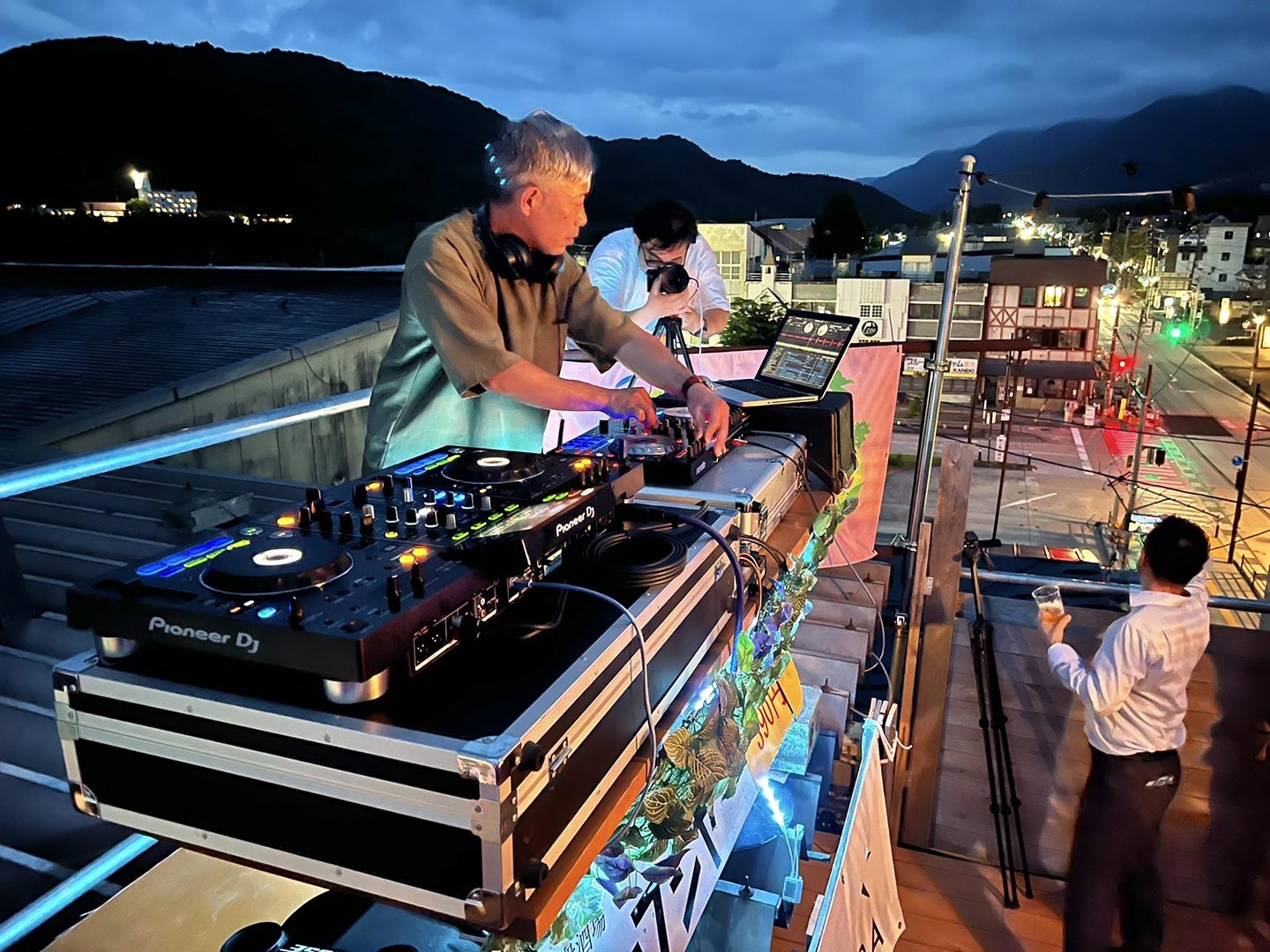 夕暮れの屋外イベントでDJプレイする、白馬駅長・古畑幸信さん