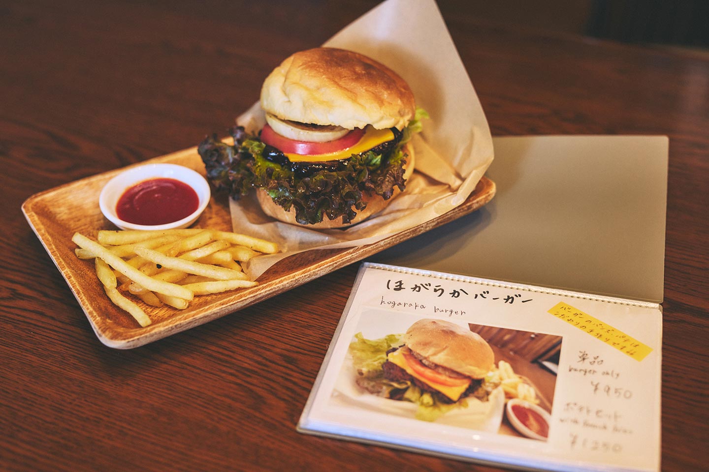 テーブルに置かれた、できたてのほがらかバーガーセットとメニュー