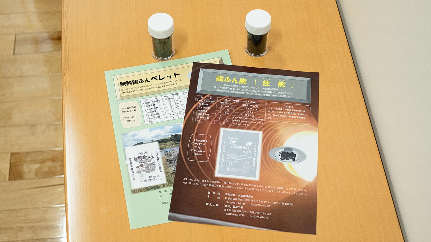 「鶏ふん炭（バイオ炭）」（右）と「醗酵鶏ふんペレット」（左）のサンプルと資料