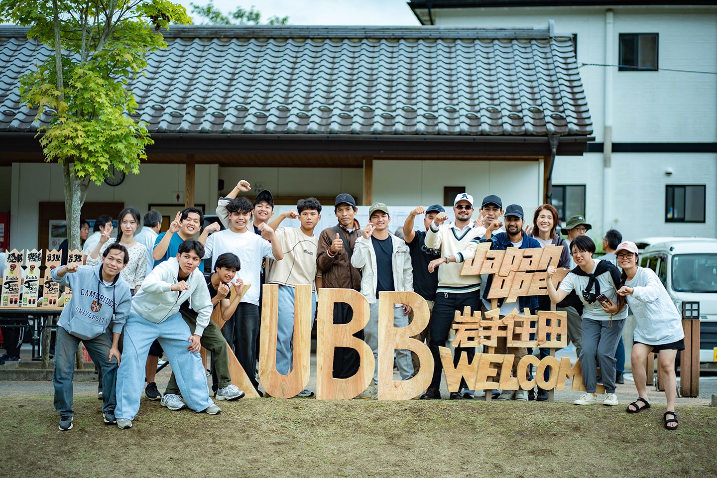 「KUBB」の文字をかたどった木製のボードとともに笑顔で記念撮影する参加者たち