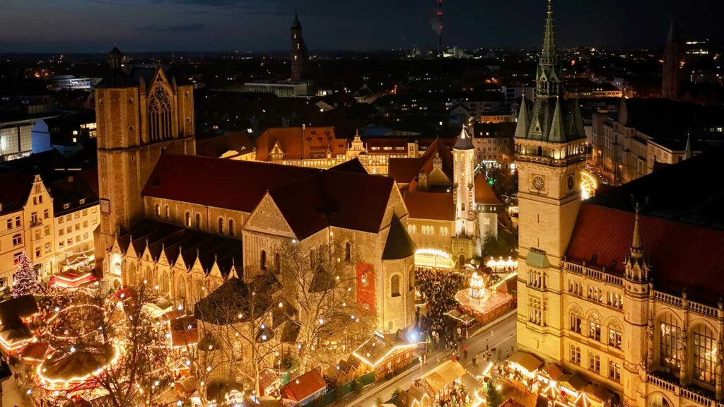 たくさんの光でライトアップされているクリスマスマーケット。上から見下ろすと、石造りの時計台や建物が広場を囲んでいる