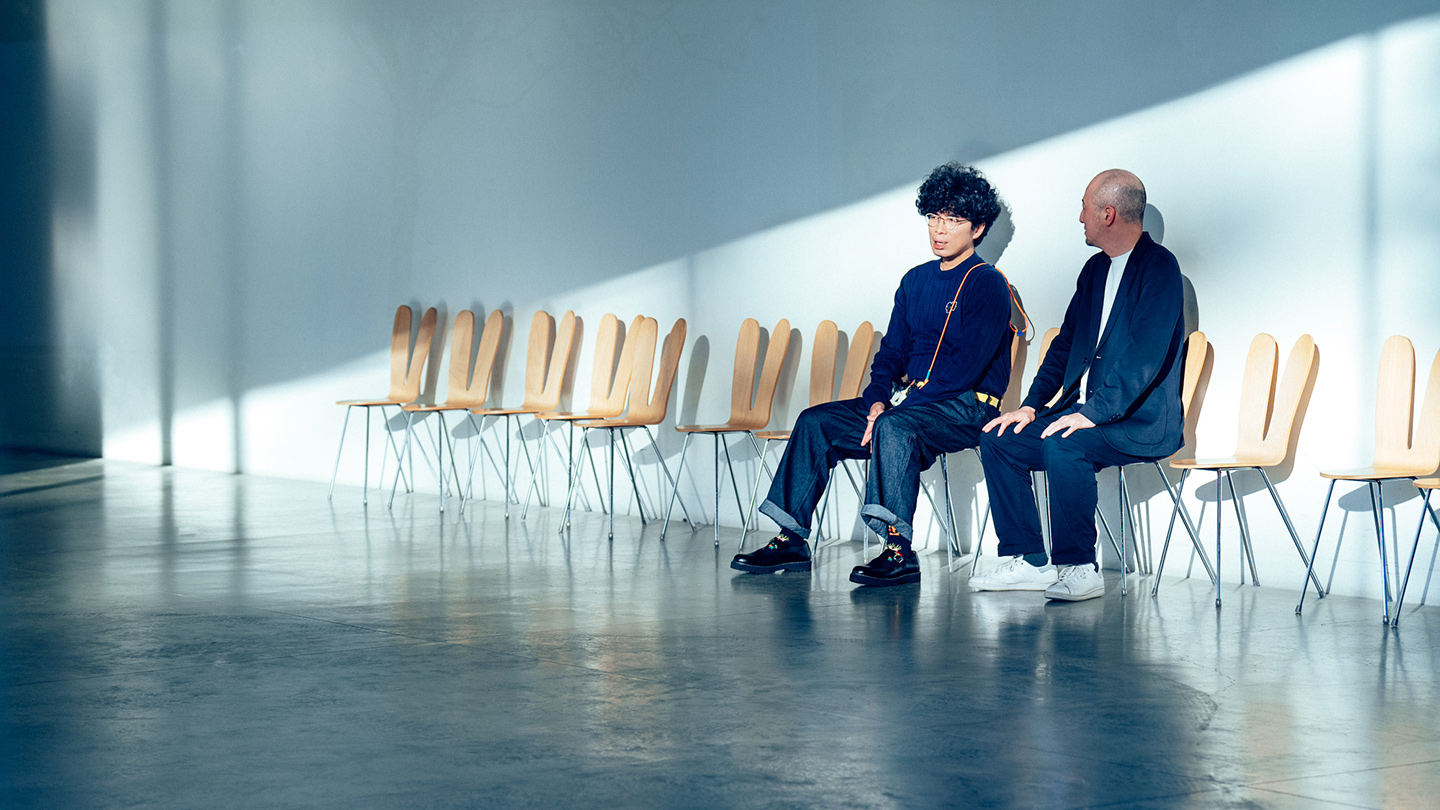 片桐仁さんと鷲田めるろさんが、背もたれがうさぎの耳の形をした椅子に横並びで腰掛けて話し合う様子