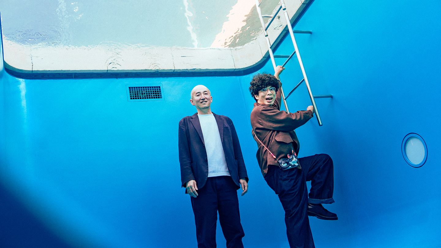 『スイミング・プール』の地下部で、カメラ目線の鷲田めるろさんと、はしごに手をかける片桐仁さん