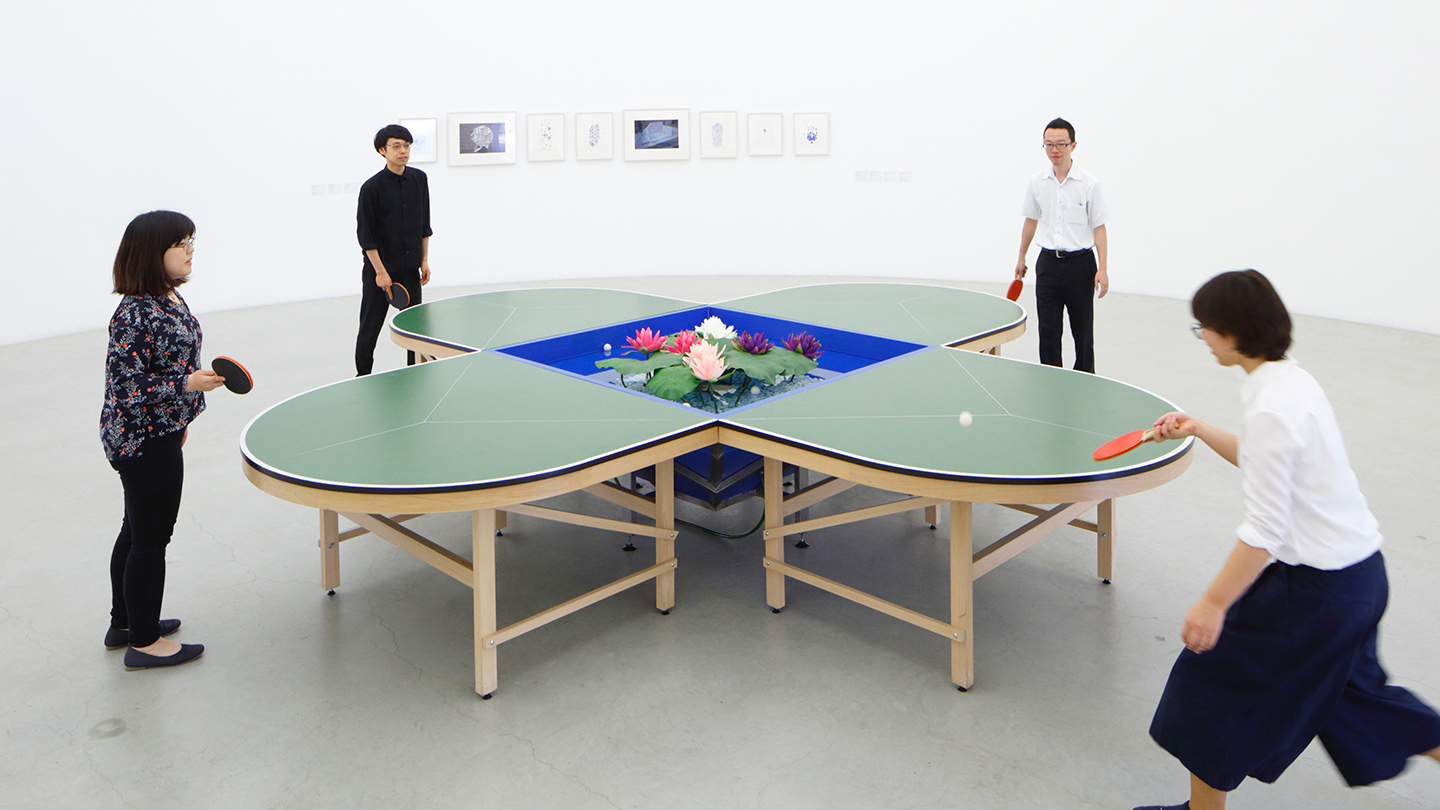 十字型に交差する卓球台が花びらの形になっている作品。4人が4方向からボールを打ち合って遊んでいる