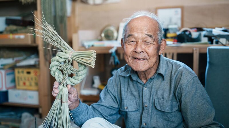 できあがったしめ縄を片手に微笑む清さん