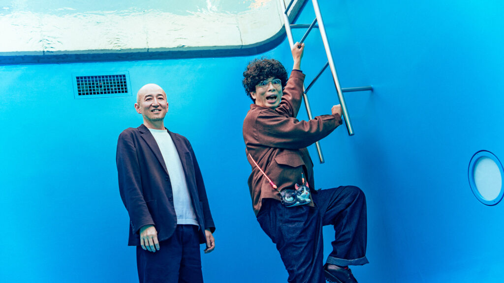 恒久展示作品『スイミング・プール』の地下空間で、笑顔の鷲田めるろさんと、はしごに手をかける片桐仁さん