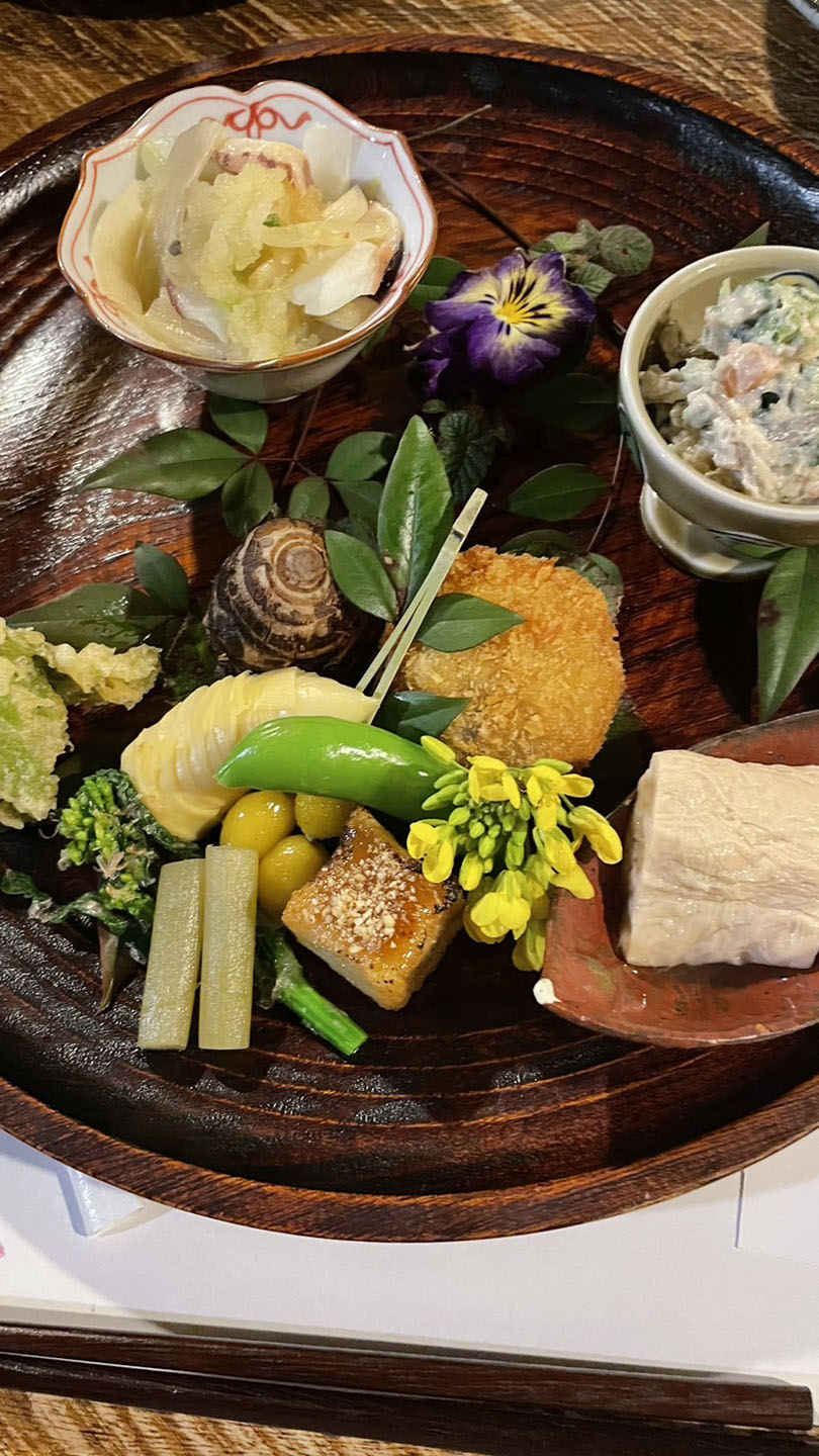 盆の上に盛り付けられた湯葉や天ぷらなどの料理