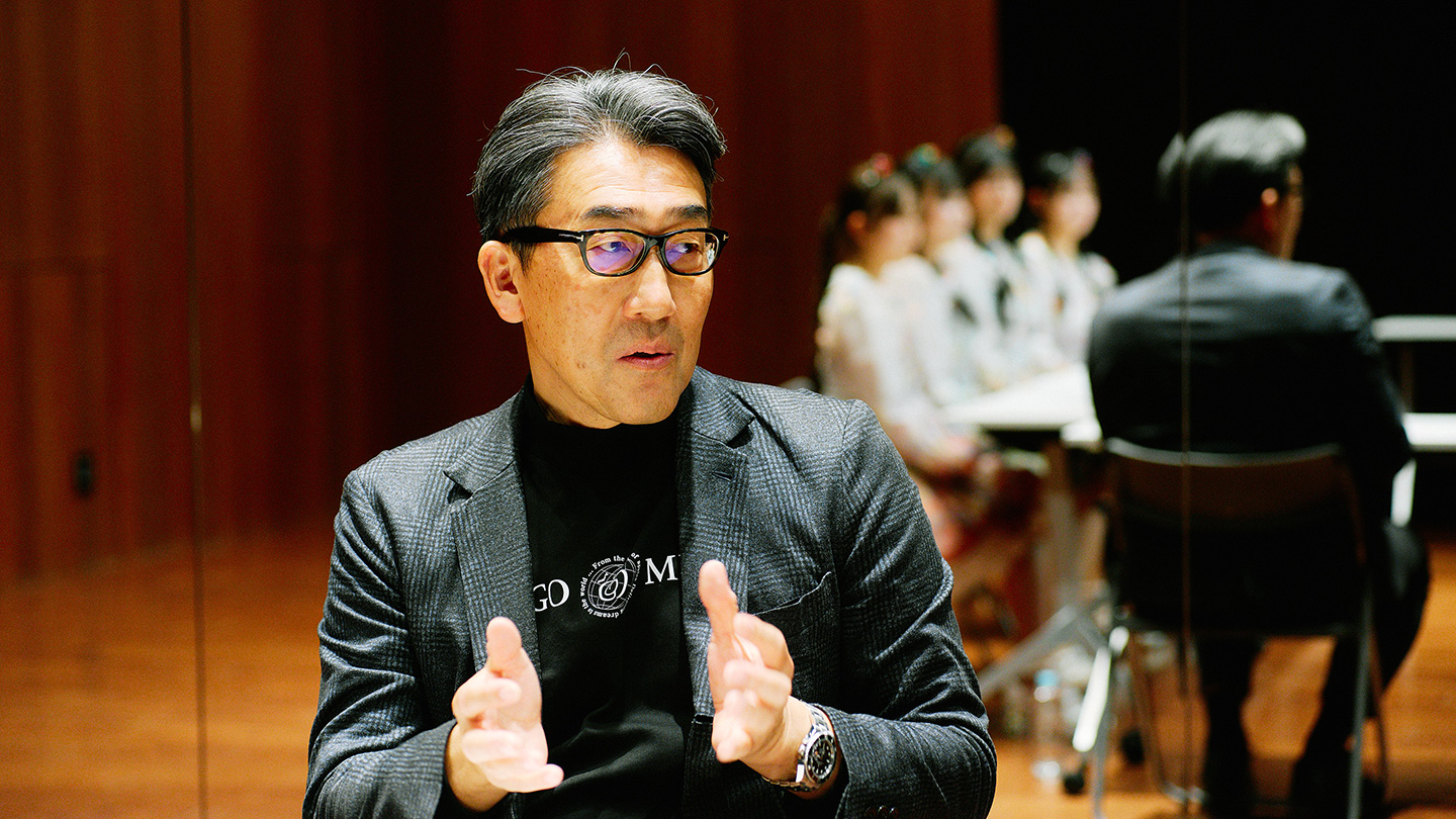 ジャケットを着て、手振りを加えて話す樋川新一さん