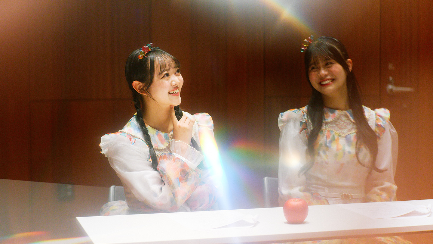 青森の伝統工芸品「津軽びいどろ」の柄をイメージした衣装を着て、笑顔で話をしているスターキングデリシャスさんと金星さん