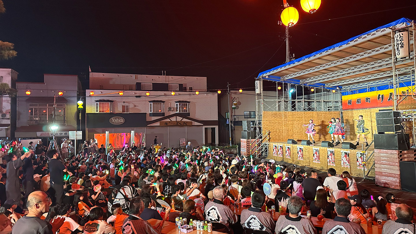 夜のステージで観客の前でパフォーマンスをするりんご娘