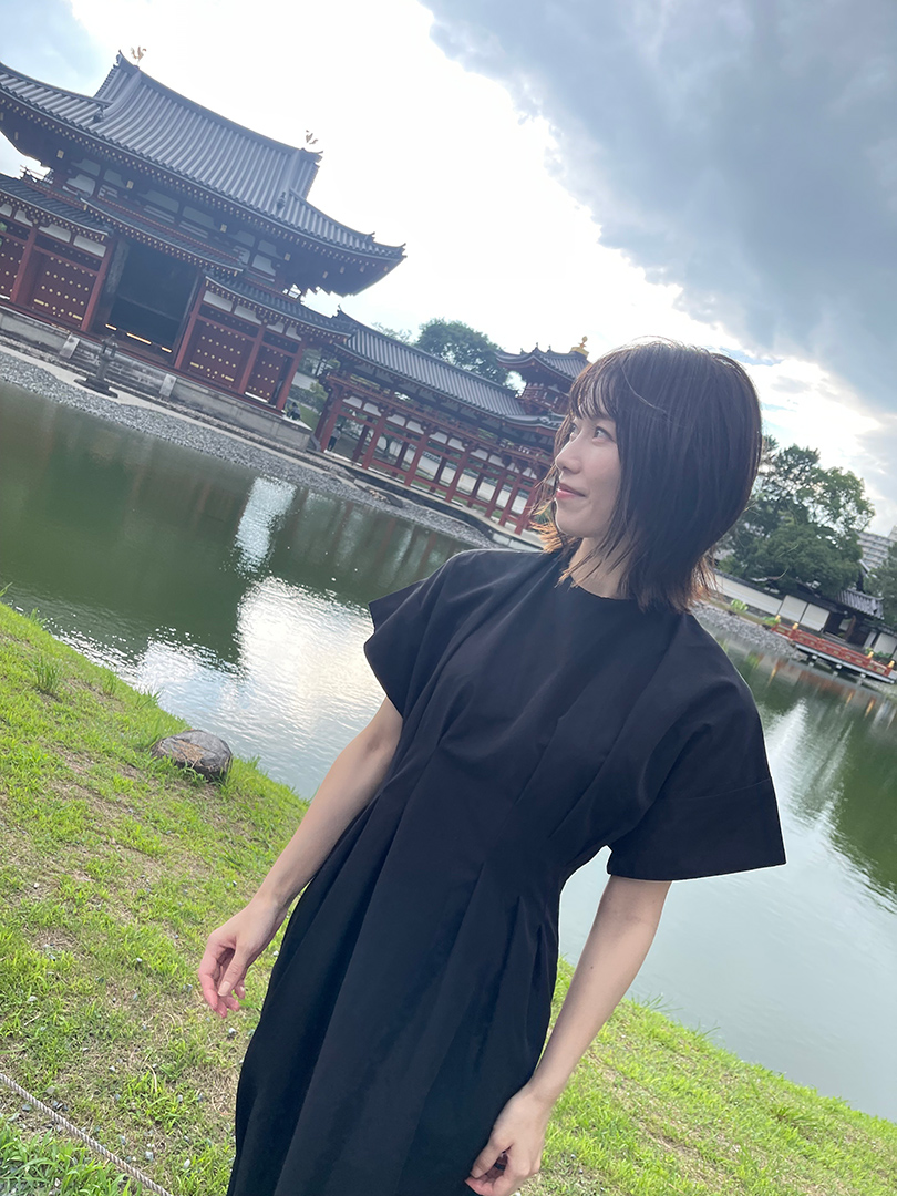 平等院鳳凰堂を背景に、池のほとりに立つ横山由依さん