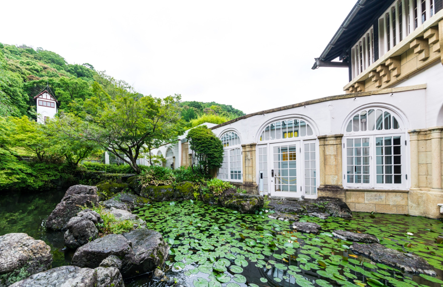 睡蓮が浮かぶ池と洋館が調和する、アサヒグループ大山崎山荘美術館の敷地内の風景