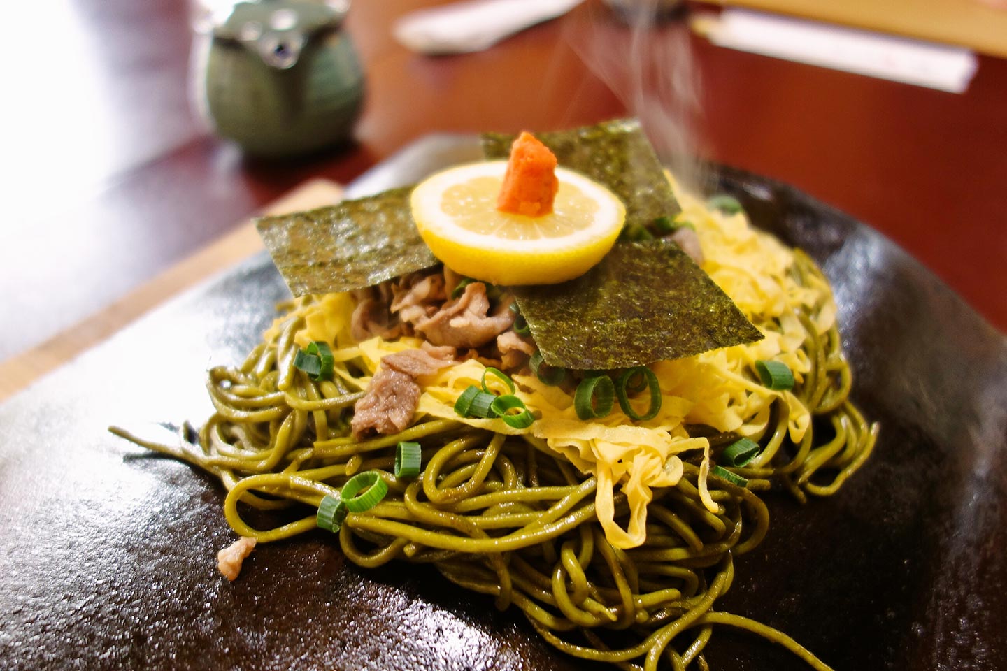 瓦の上に、茶そば、錦糸卵、牛肉、海苔、レモン、もみじおろしがのった瓦そば