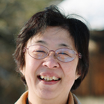 雪景色を背景に立つ前川さん