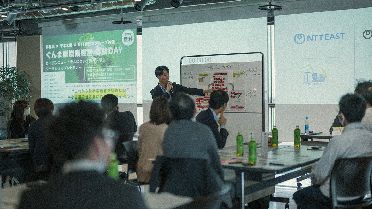 SX推進に関する説明会の様子。中央に立ちホワイトボードを使って説明する男性と、話に聞き入る人々の後ろ姿