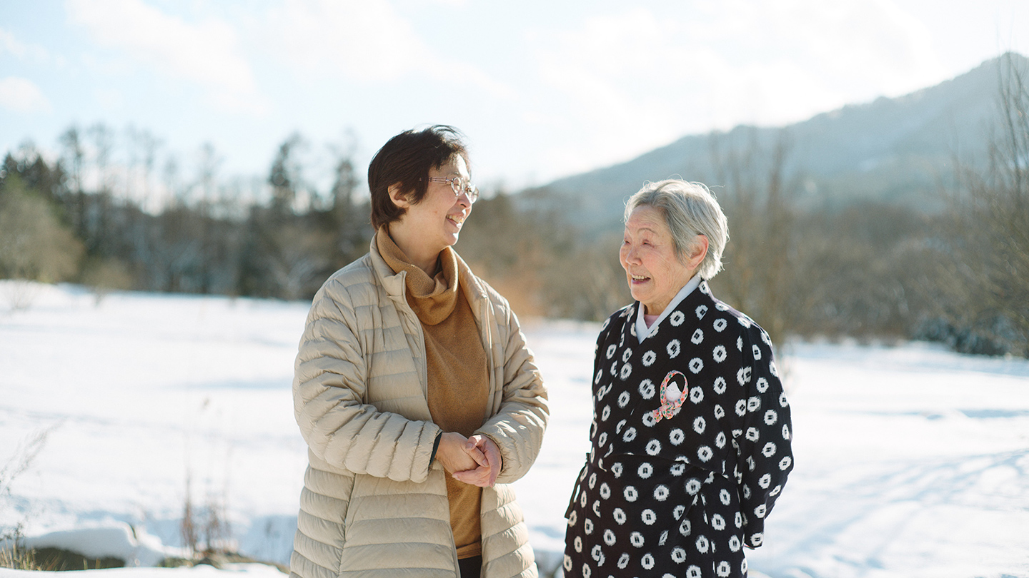 雪景色を背景に語り合う前川さんと細越澤さん