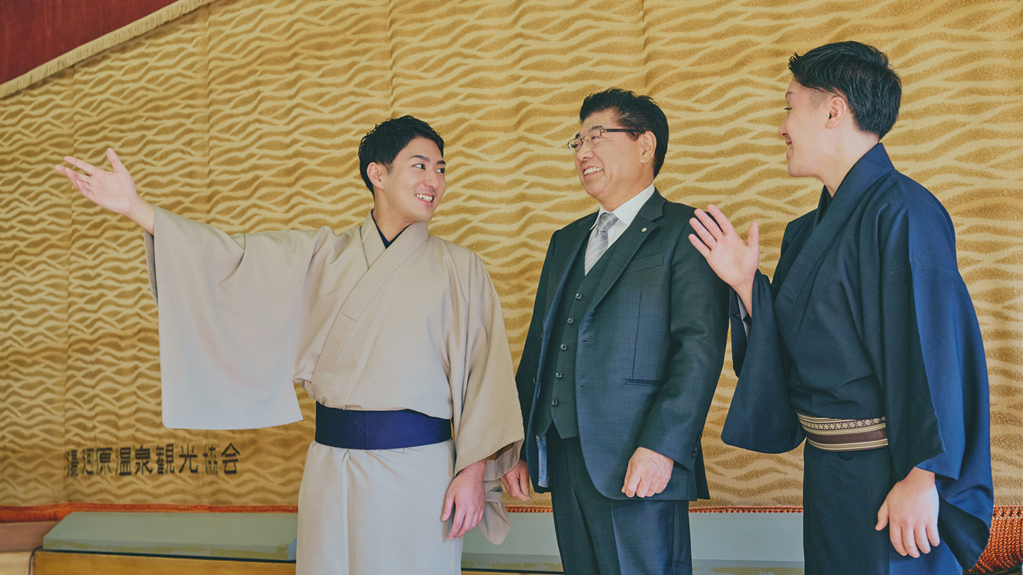 「湯河原温泉観光協会」と書かれた幕を背景に話す、中村橋之助さんと湯河原温泉観光協会の石田会長、藤間直三さん