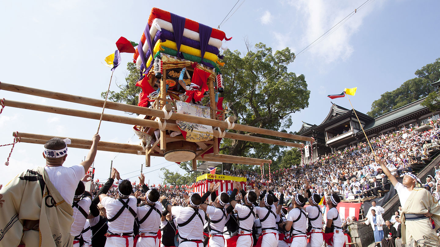 「コッコデショ」と呼ばれる演し物。「太鼓台」と呼ばれる山車を天に向けて差し上げる担ぎ手。それらを観客席で見るたくさんの人たち