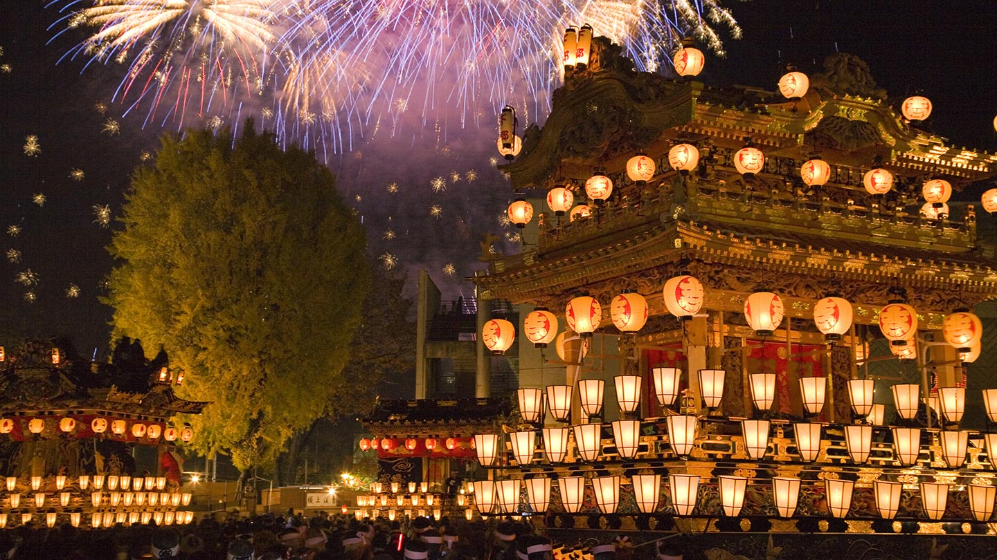 提灯がたくさんついた巨大な屋台と、夜空に打ち上がる花火