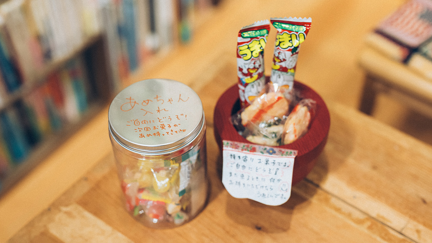 図書スペースの机の上に置かれた、お菓子が入った瓶と木の器