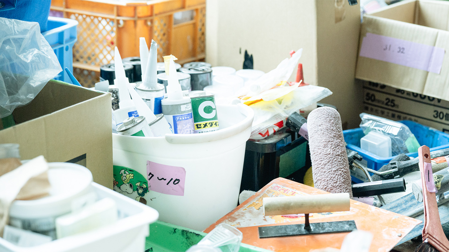 7～10と書かれたバケツのなかに、接着剤やコーキング材がいくつも保管されている。段ボールにも番号が振られて管理されている。塗装や左官に使う道具も積みあがっている