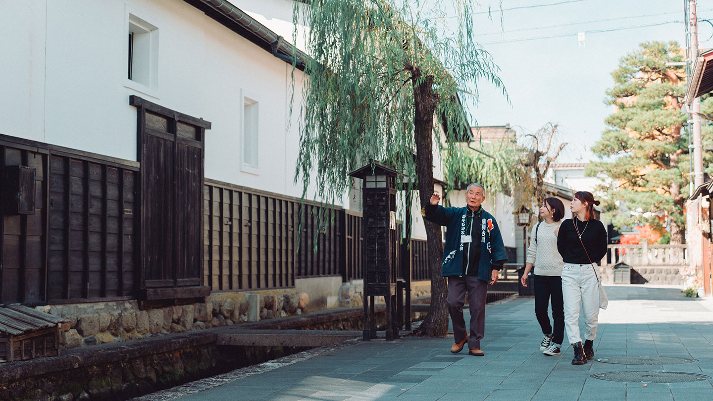 飛騨市の街を歩く観光客と観光案内人