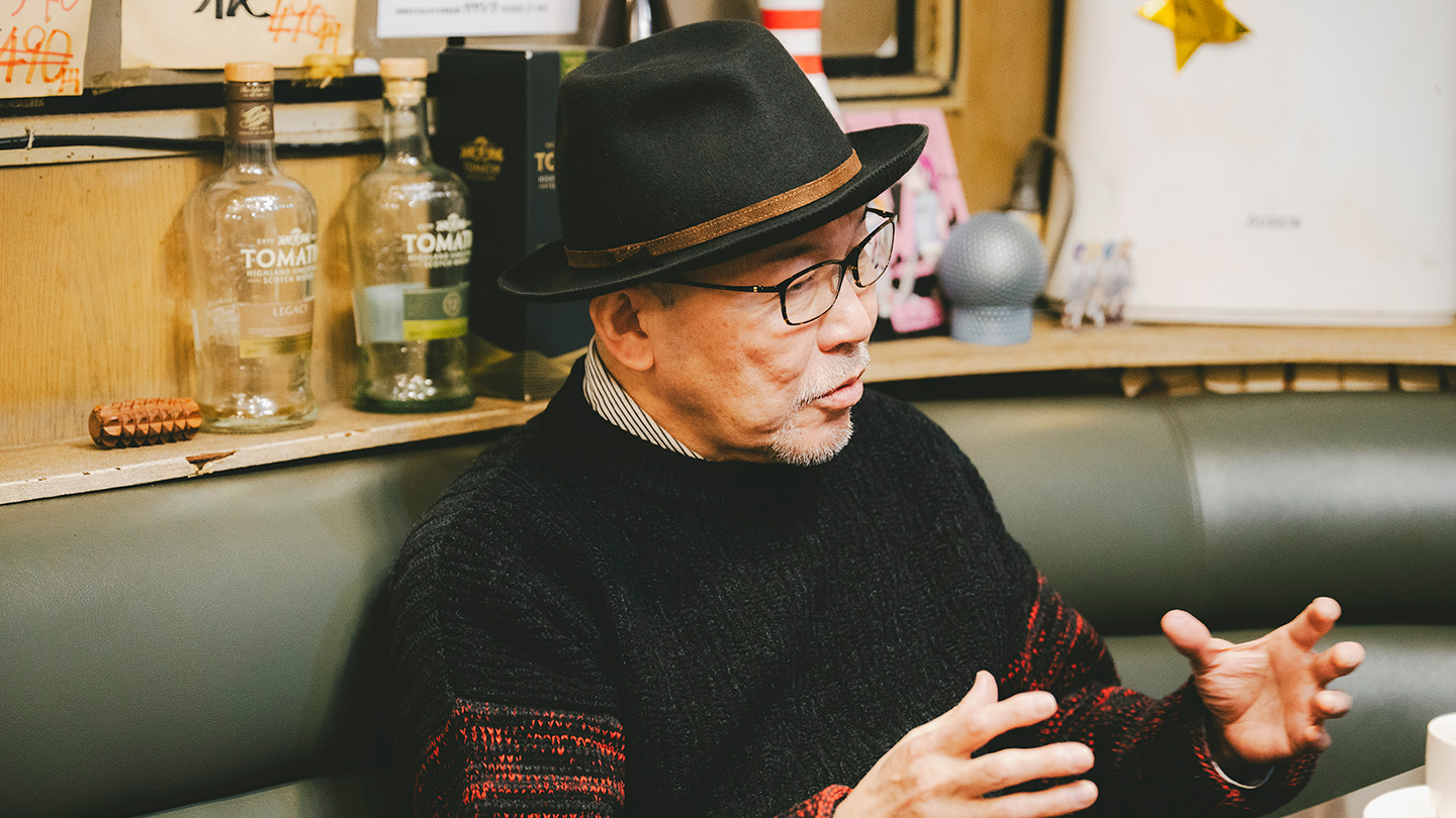 喫茶店のソファ席で身振りを交えながら話す久住さん