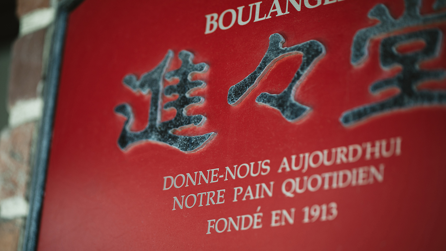 進々堂の看板。店名と「Donne-nous aujourd'hui notre pain quotidien」という言葉が刻まれている