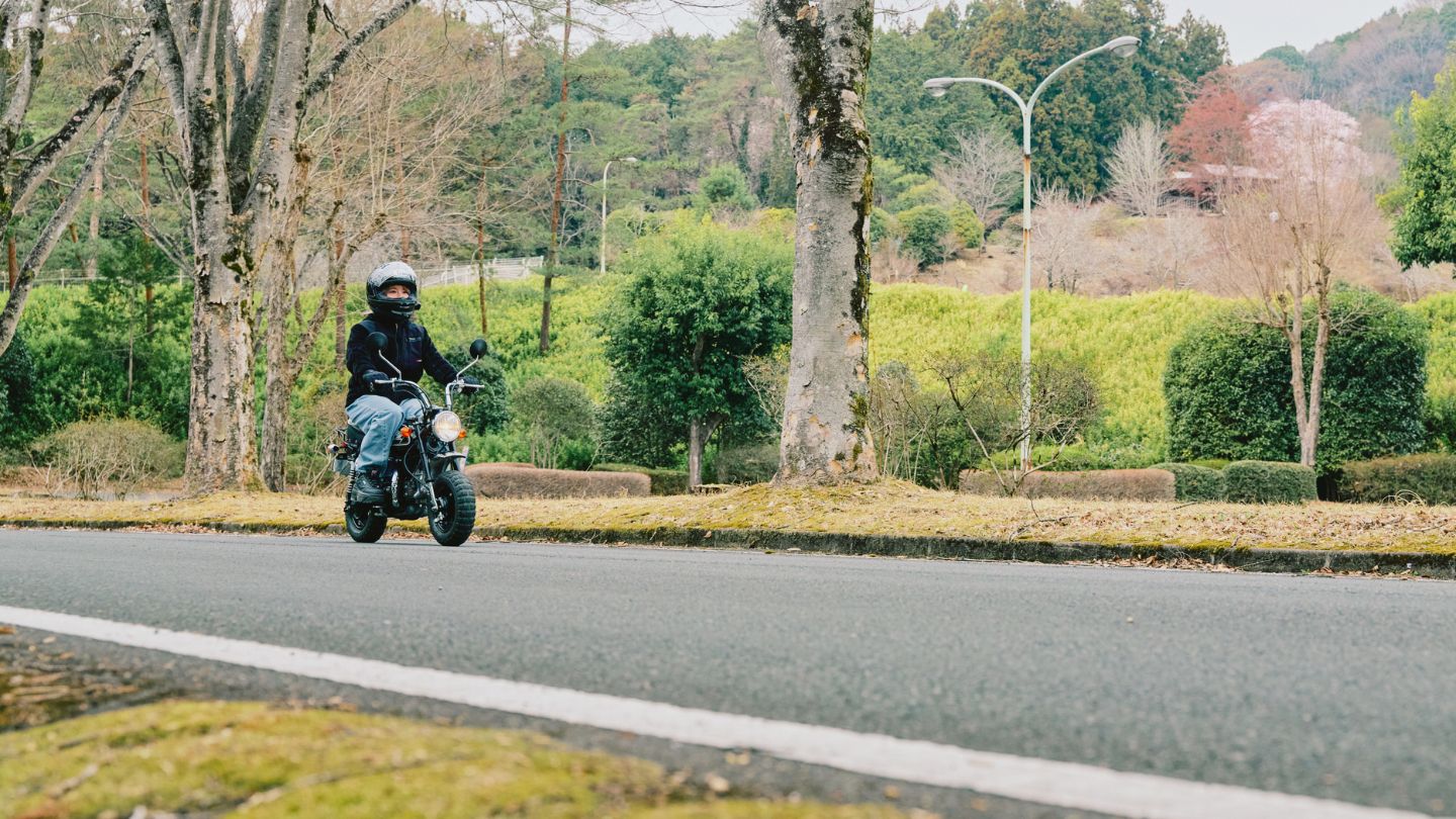 豊かな自然を背景に、車道をバイクで走るこつぶさん