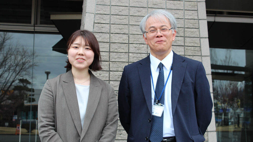 取材を受けた二人が建物の前で並んで立っている