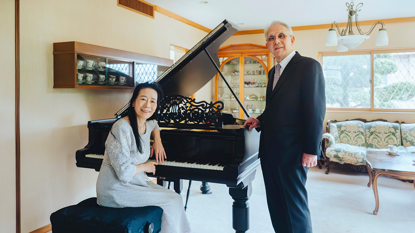 グランドピアノの前に座る小山実稚恵さんと、その横に立つ今井環さん