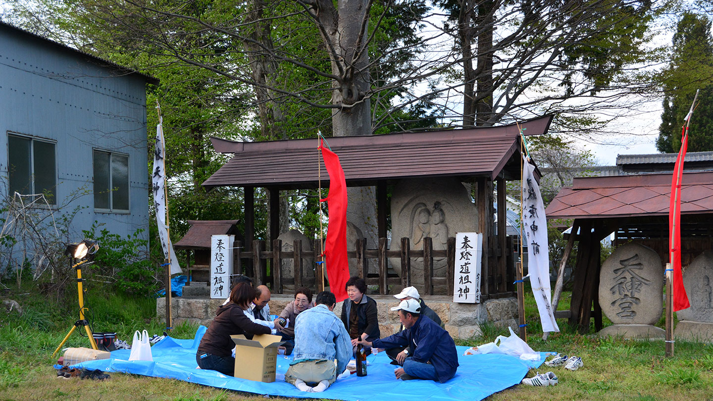 広場にブルーシートを引いて座る人々