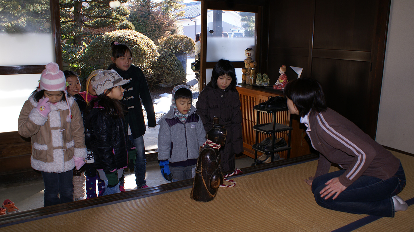 家へ上がる子どもたちとそれを迎える家主