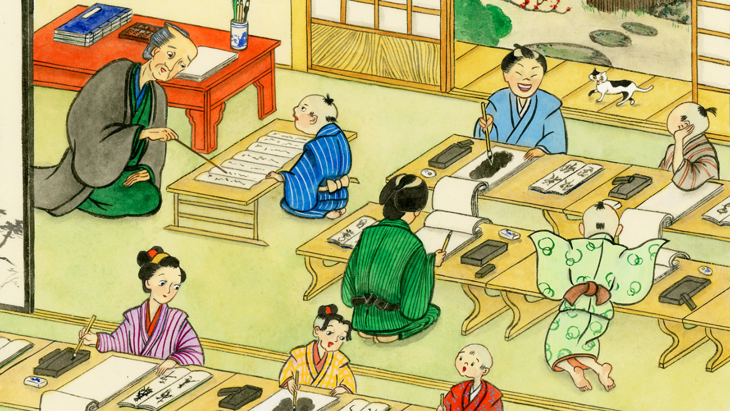 机が並んだ部屋で、着物を着た子どもたちが読み書きを先生から教えてもらっている
