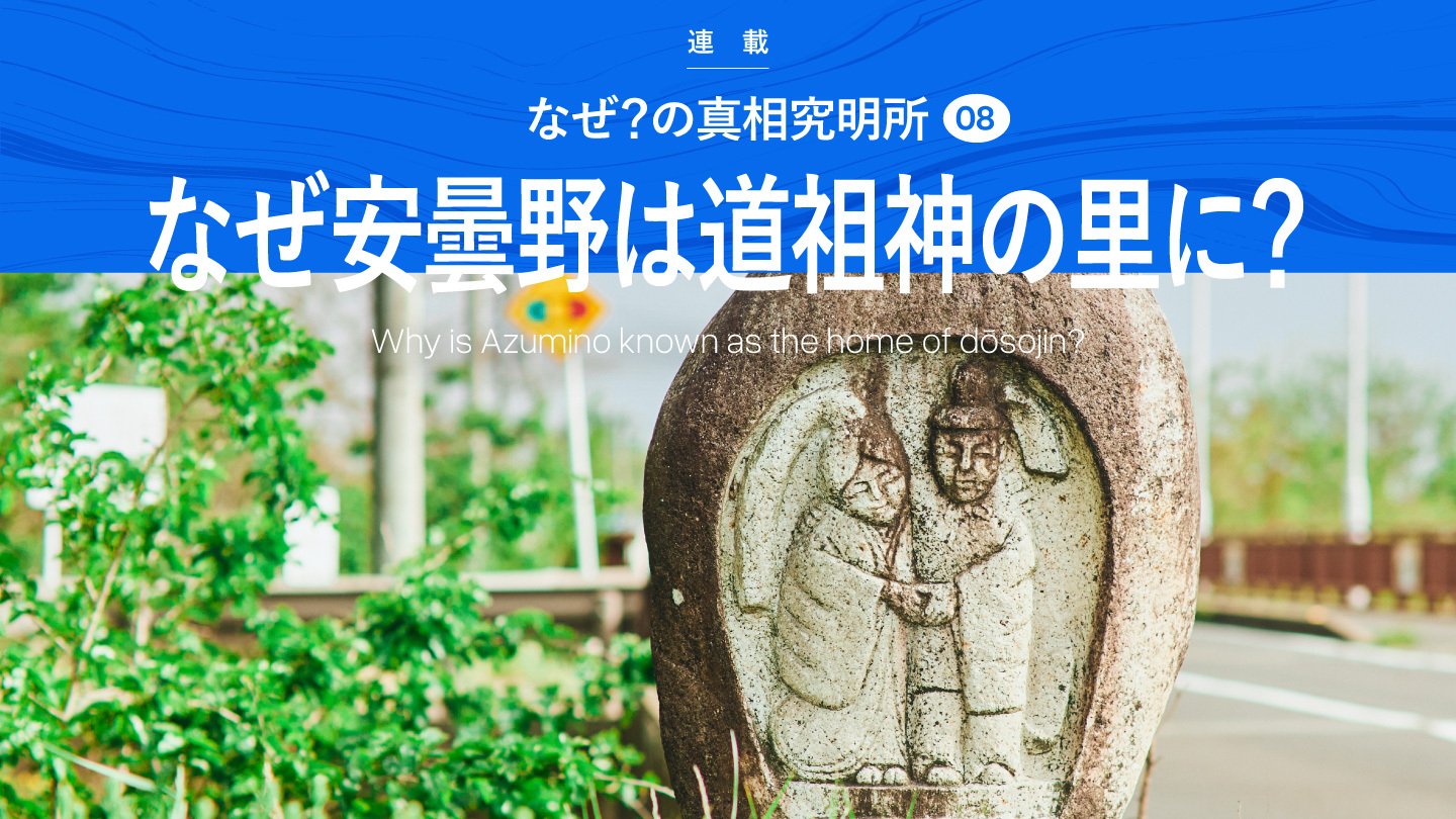 男女が対になっている道祖神碑。その上に「なぜ？の真相究明所08 / なぜ安曇野は道祖神の里に？ / Why Is Azumino Known as the Home of Dōsojin?」の文字