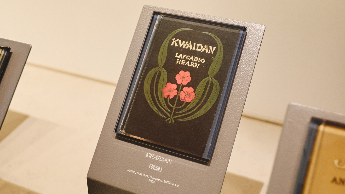 黒い装丁に赤い花と緑の花が図案化され、『KWAIDAN　LAFCADIO HEARN』の英字が印刷された『怪談』初版本の表紙。