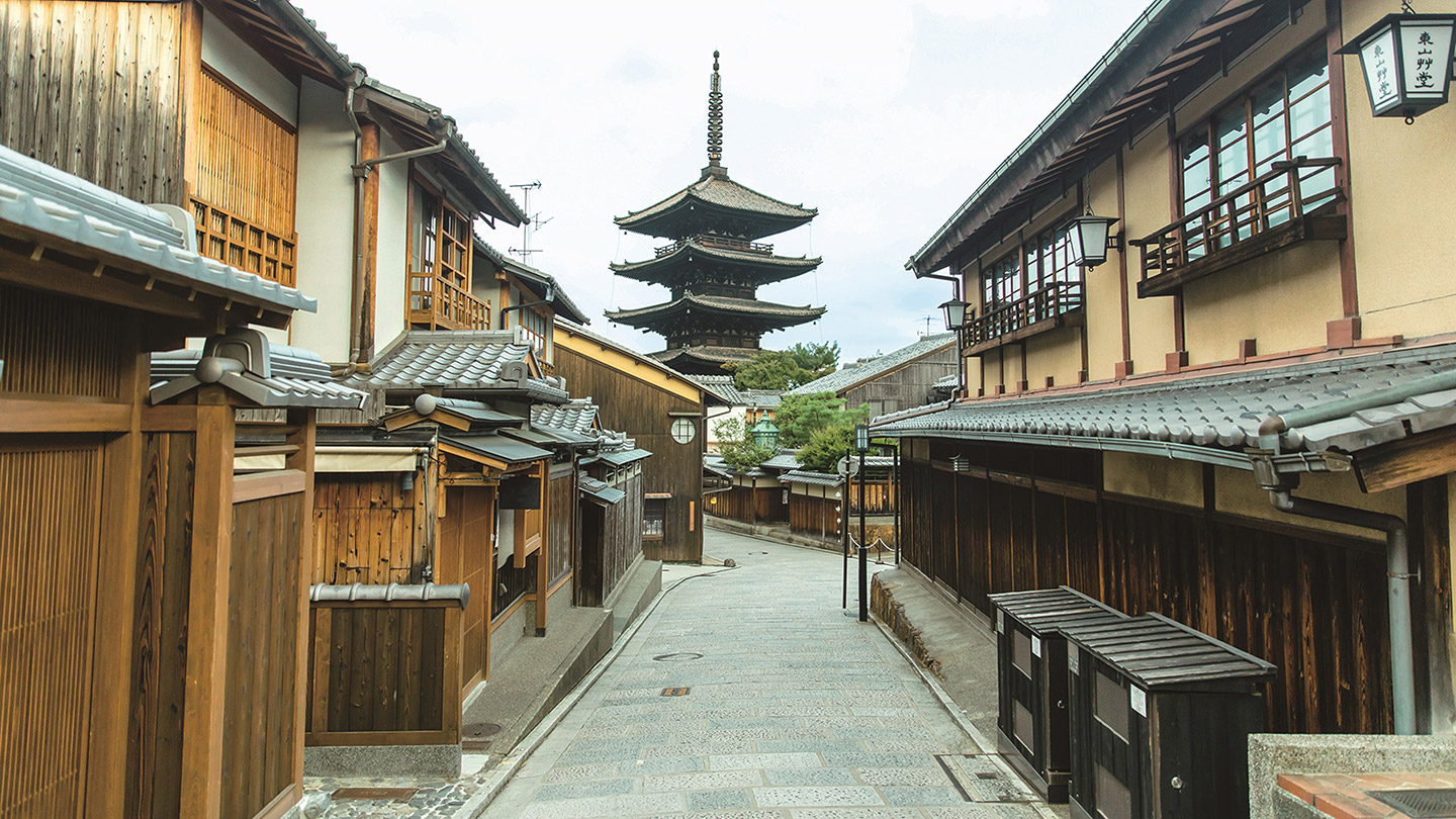 石畳の道の両脇に建ち並ぶ古い家、奥に五重塔