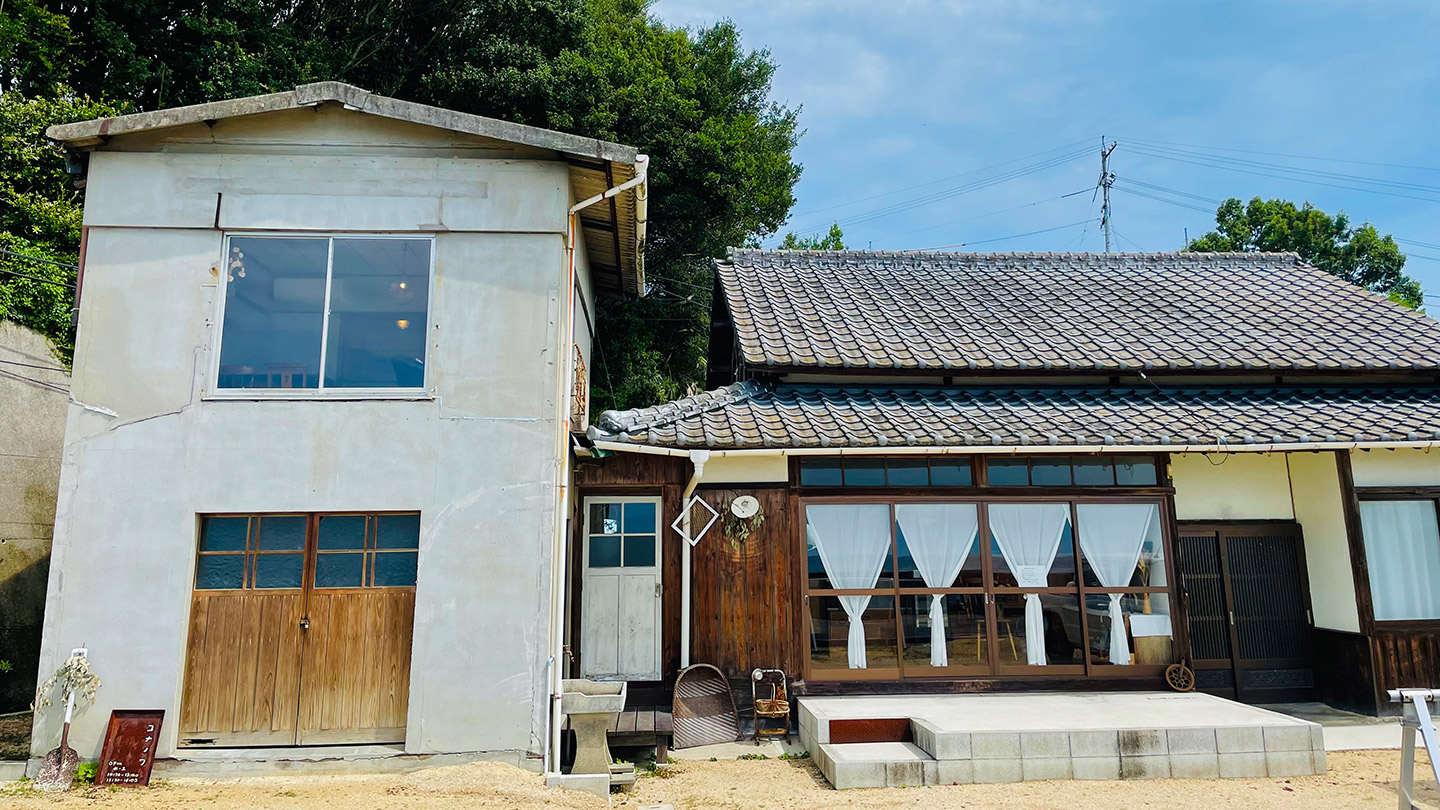 白い蔵と瓦屋根の古民家が並んでいる