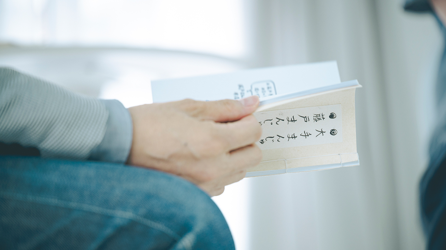 「おまんじゅうZINE」を手に取る仲俣暁生さん
