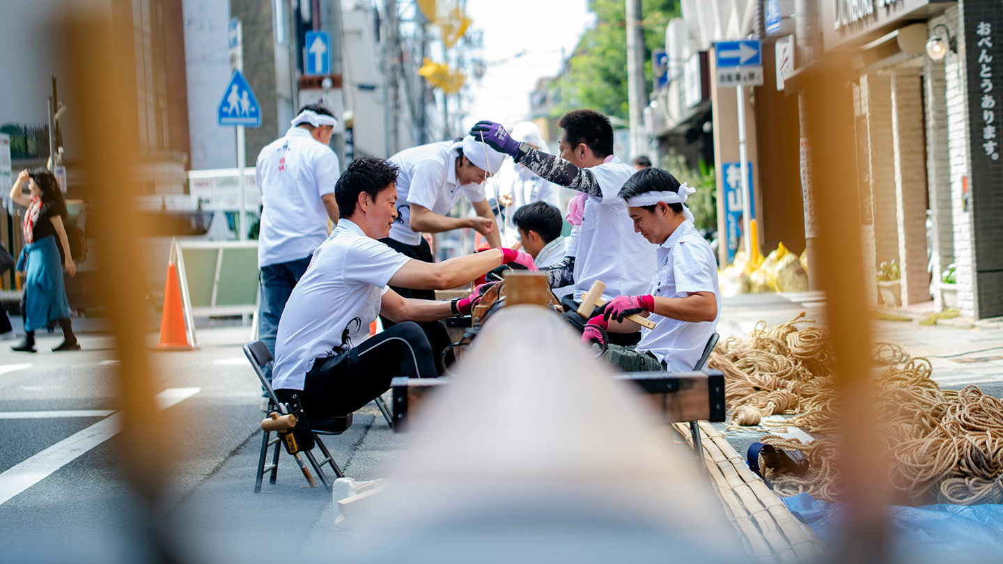 複数人の人が座ってお祭りの準備をしている