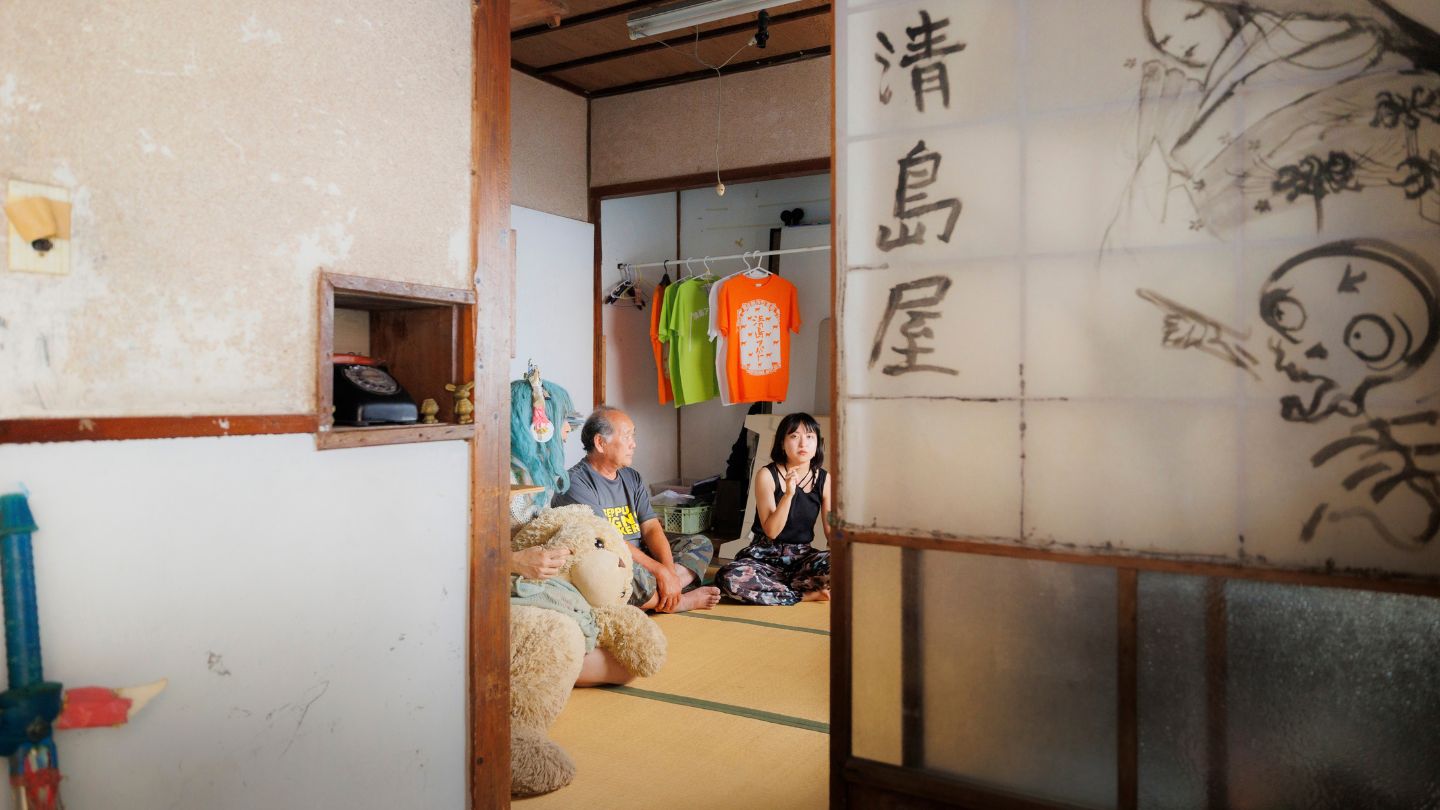 障子戸の向こうに、アーティストと地元の人が畳の座敷で団らんしている様子が見える