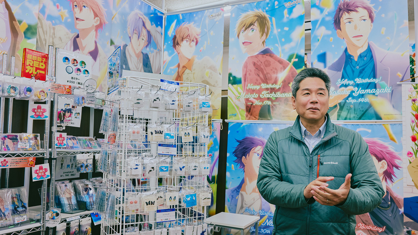 『Free!』シリーズの公式グッズに囲まれて話をする山本健太さん