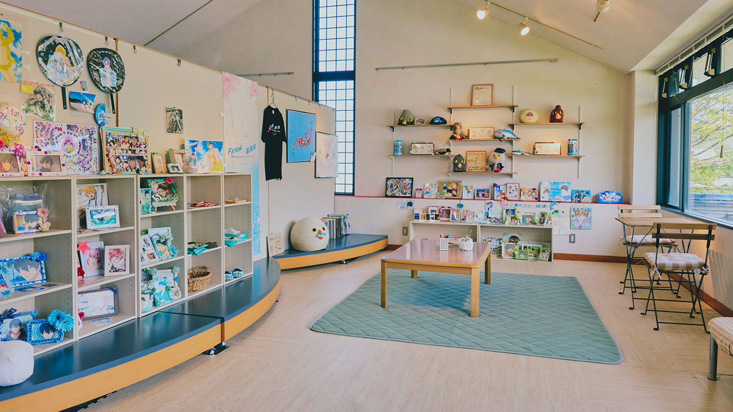 アニメキャラクターの写真やグッズが並べられた部屋