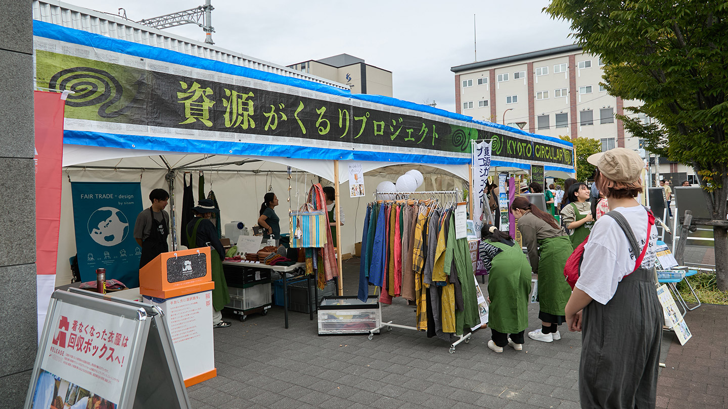 「資源がくるりプロジェクト」と書かれたブースの中にハンガーラックにかけられた服がある
