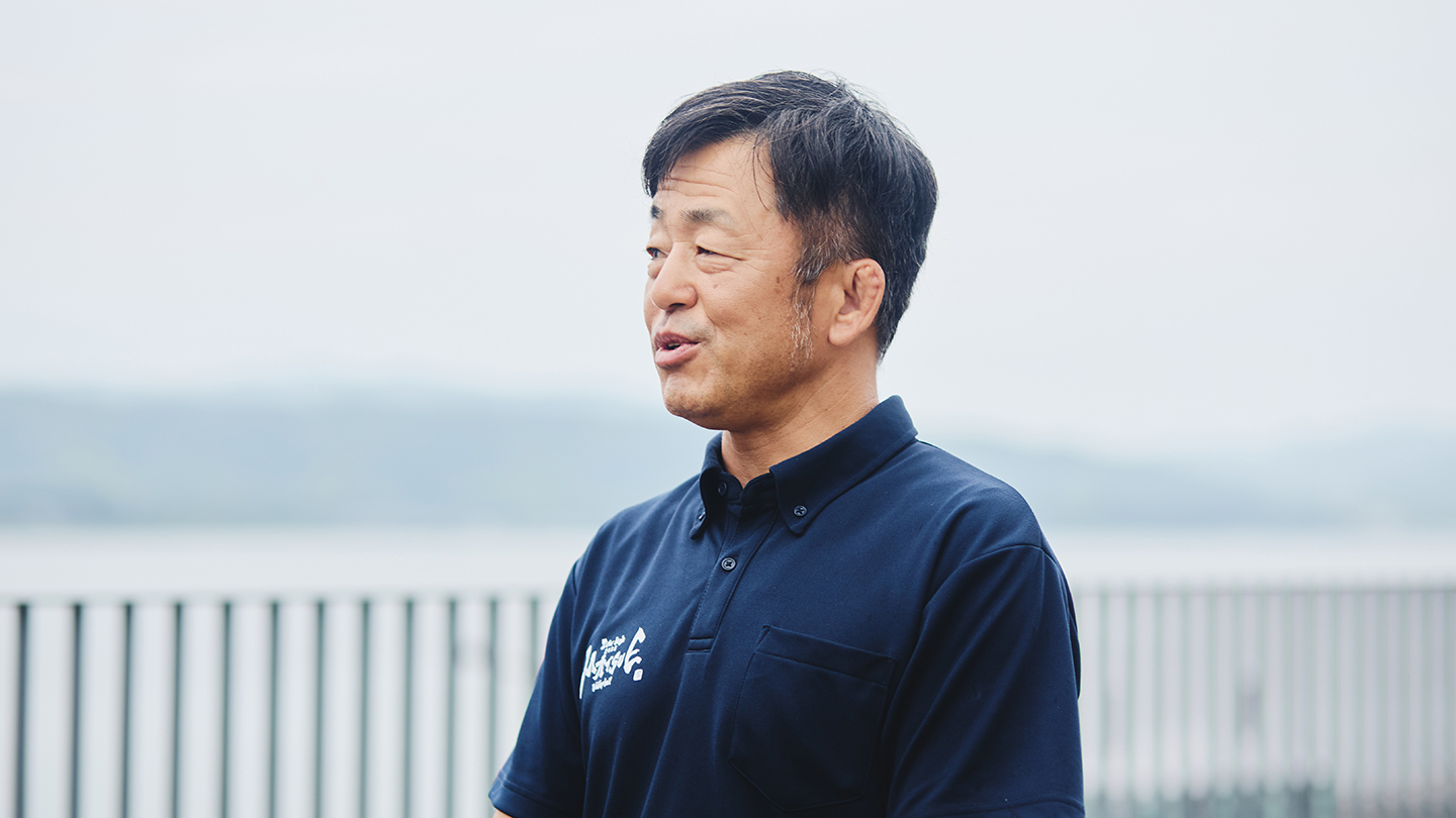 宍道湖を背景に笑って話す佐々木武さん