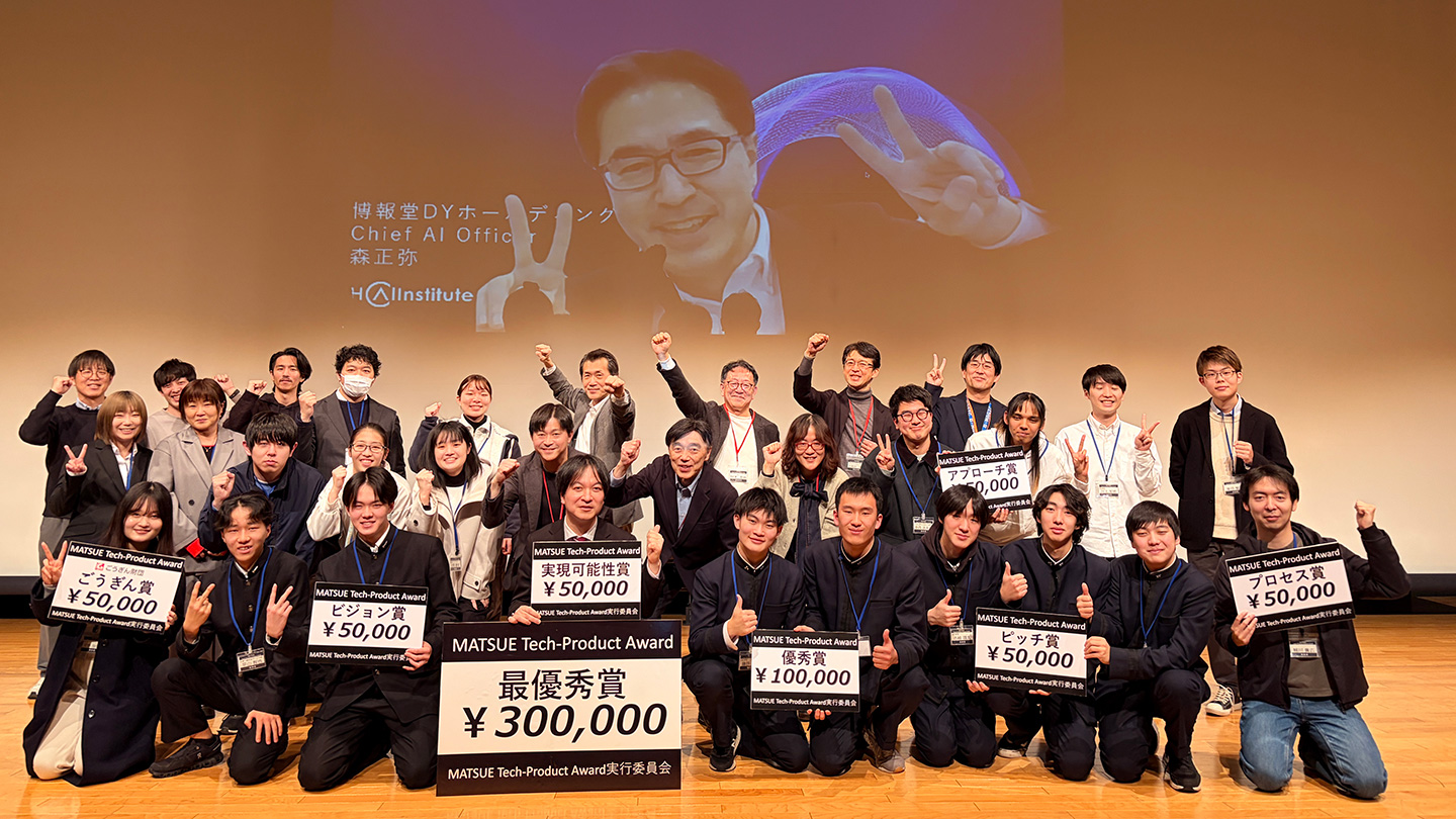 「実現可能性賞」「最優秀賞」「アプローチ賞」などと書かれた目録を掲げて笑うイベント参加者たち