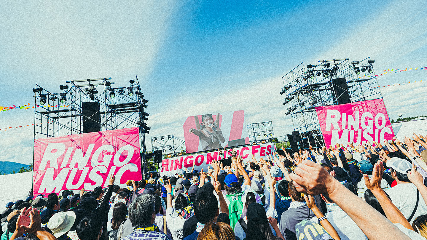 青空の下、「RINGO MUSIC FES.」のステージに向かって手を掲げる大勢の観客