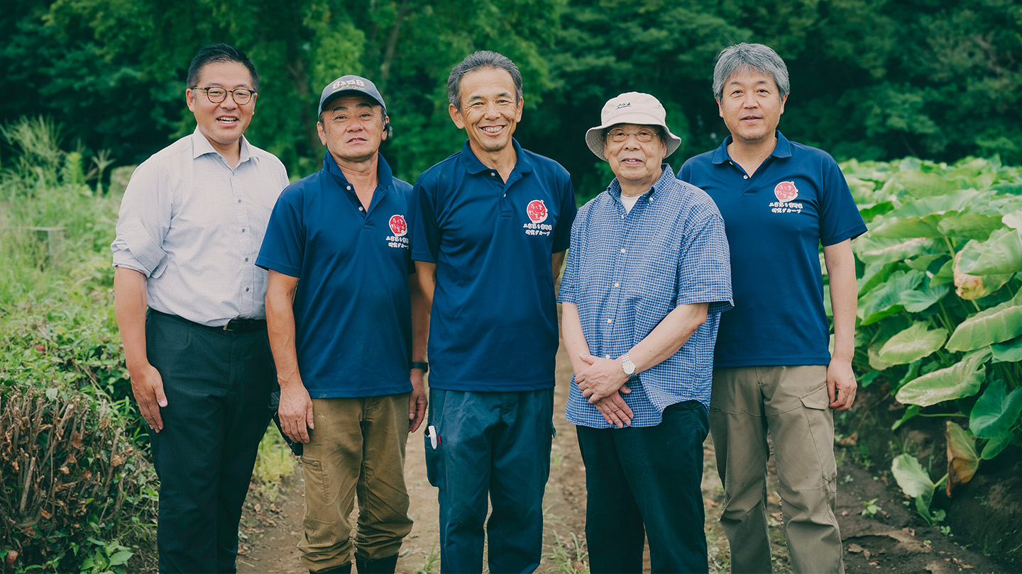 畑を背景に並ぶ、江田直也さん、早川光男さん、早川徹さん、犬井正さん、井田和宏さん